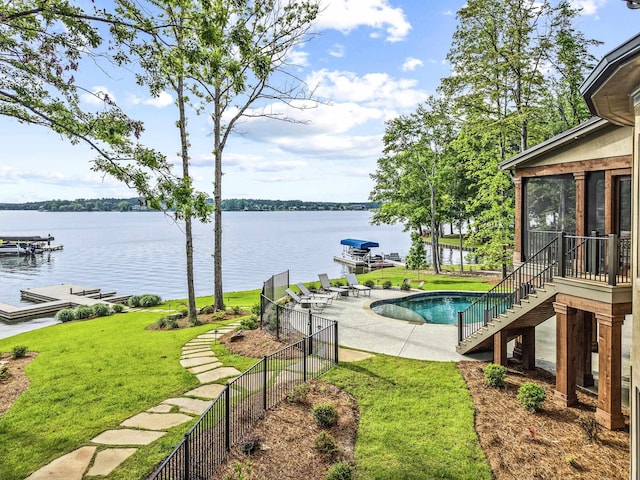 exterior space featuring a water view, stairs, a sunroom, and a yard