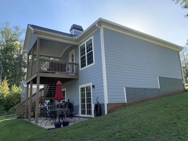 back of house with stairs, a patio area, central AC unit, and a lawn