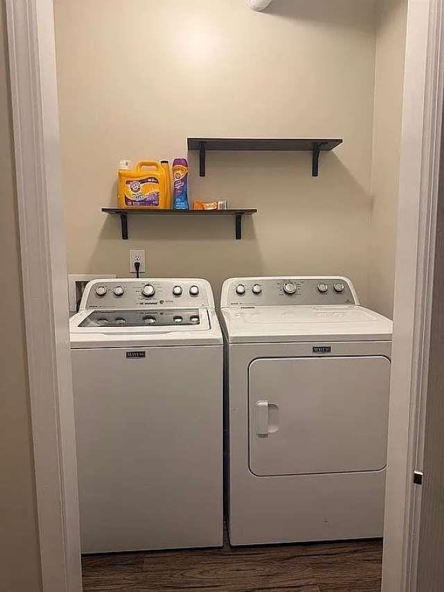 laundry area featuring dark wood-style floors, washing machine and dryer, and laundry area