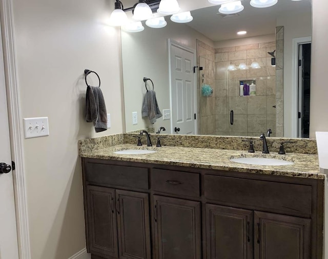 bathroom featuring a sink, double vanity, and a shower stall