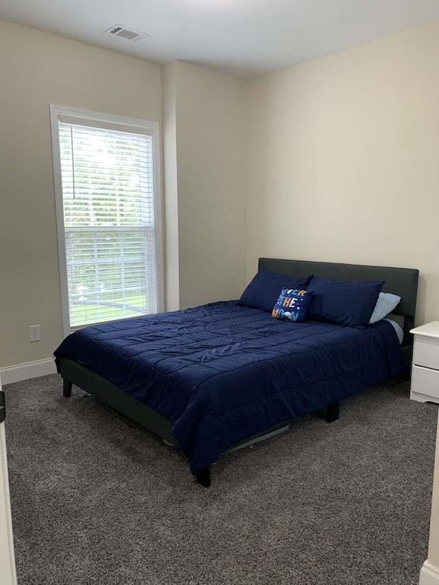 carpeted bedroom with visible vents and baseboards