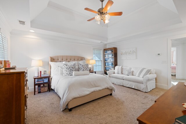 carpeted bedroom featuring a tray ceiling, ornamental molding, and ceiling fan
