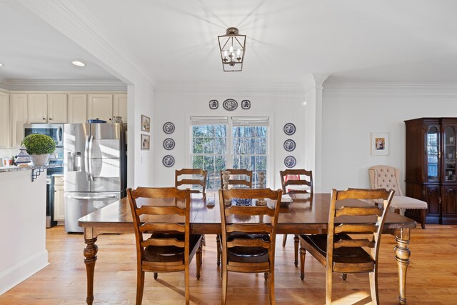 dining room featuring crown molding, an inviting chandelier, and light hardwood / wood-style floors