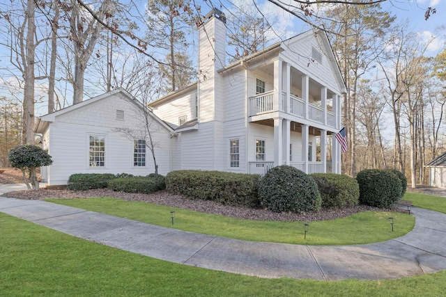 view of front of property with a balcony and a front lawn