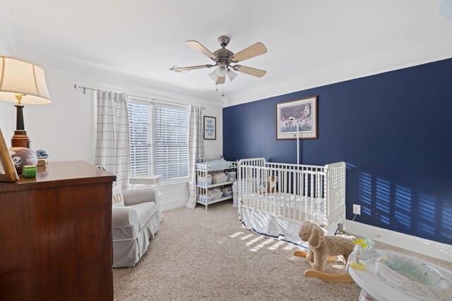 carpeted bedroom featuring crown molding, ceiling fan, and a nursery area