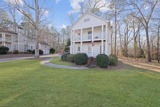 view of front of property featuring a front yard and a balcony