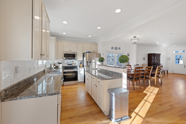 kitchen featuring a kitchen island, white cabinetry, sink, light hardwood / wood-style floors, and stainless steel appliances