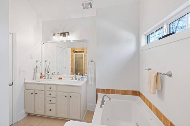 bathroom featuring tile patterned floors, vanity, and plus walk in shower