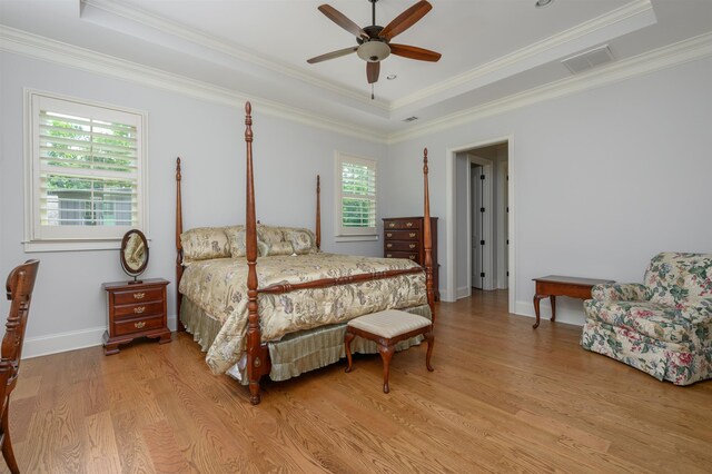 1020 Fairway Ridge Cir, Greensboro, GA 30642 - bedroom with a tray ceiling, light wood-style flooring, baseboards, ornamental molding, and ceiling fan