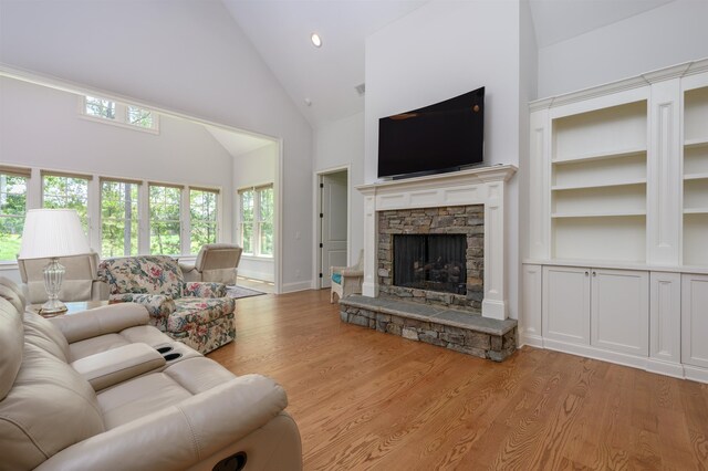 1020 Fairway Ridge Cir, Greensboro, GA 30642 - living room featuring high vaulted ceiling, light wood finished floors, a stone fireplace, baseboards, and recessed lighting