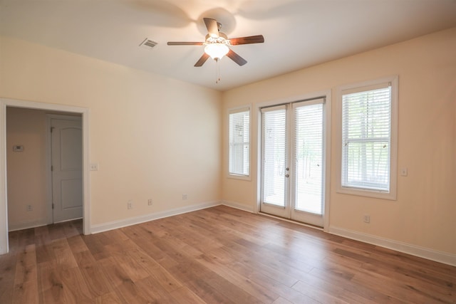 spare room featuring hardwood / wood-style floors, ceiling fan, and french doors