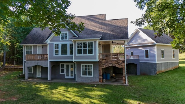 rear view of house featuring ceiling fan, a balcony, a yard, and a patio