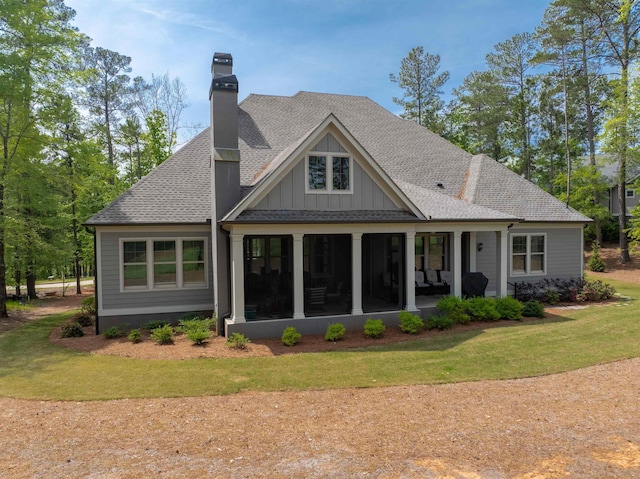 back of house with a lawn and a sunroom