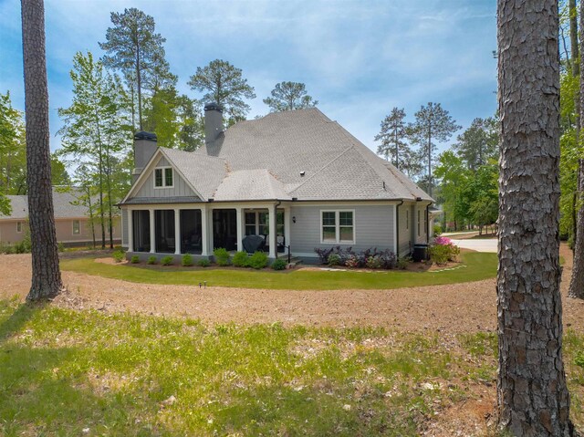 rear view of property featuring a yard and a sunroom