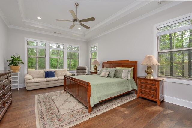 bedroom with a raised ceiling, ornamental molding, dark hardwood / wood-style floors, and ceiling fan