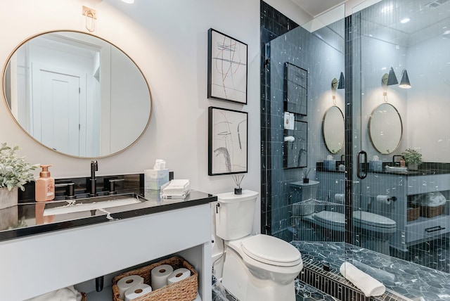 bathroom with vanity, toilet, and a shower with shower door