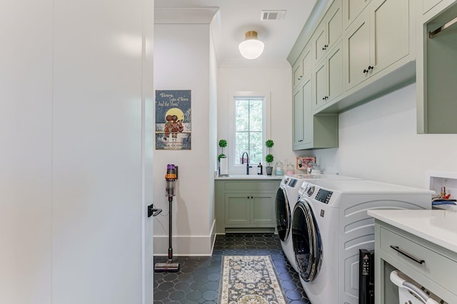 clothes washing area featuring cabinets, ornamental molding, sink, and washing machine and clothes dryer