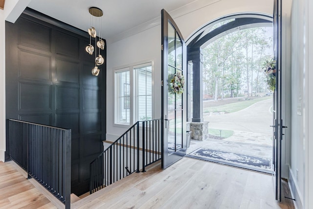 foyer entrance with hardwood / wood-style flooring, ornamental molding, and a wealth of natural light