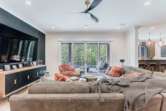 living room featuring ornamental molding, wood-type flooring, and ceiling fan