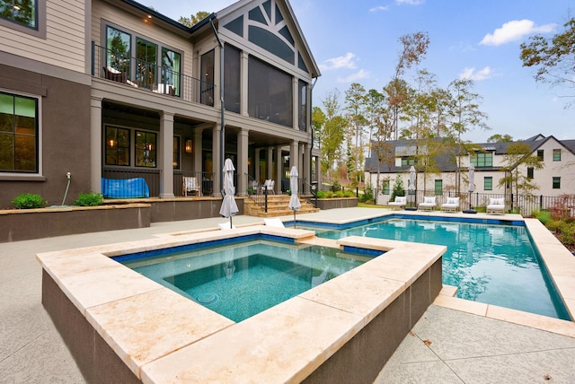 view of swimming pool with a patio and an in ground hot tub