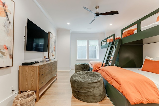 bedroom featuring light hardwood / wood-style flooring, ornamental molding, and ceiling fan