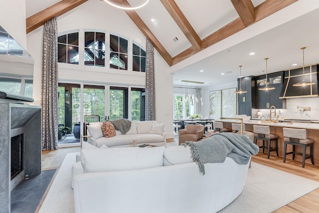 living room with a high end fireplace, wood-type flooring, beam ceiling, and high vaulted ceiling