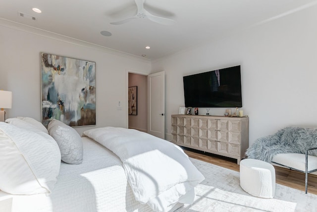 bedroom with crown molding, ceiling fan, and light wood-type flooring