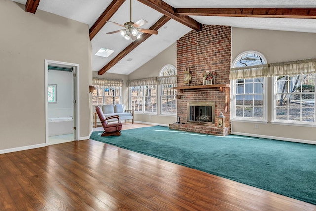 unfurnished living room featuring hardwood / wood-style flooring, high vaulted ceiling, a brick fireplace, and beamed ceiling