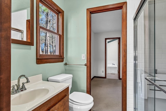 bathroom featuring vanity, walk in shower, and toilet