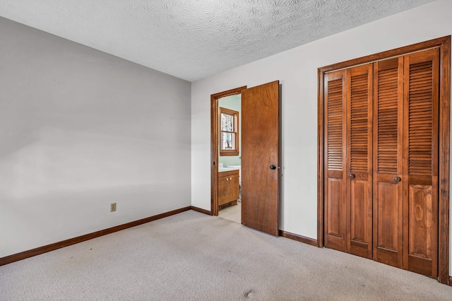 unfurnished bedroom with a closet, light carpet, and a textured ceiling