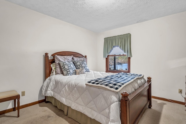 bedroom featuring light carpet and a textured ceiling