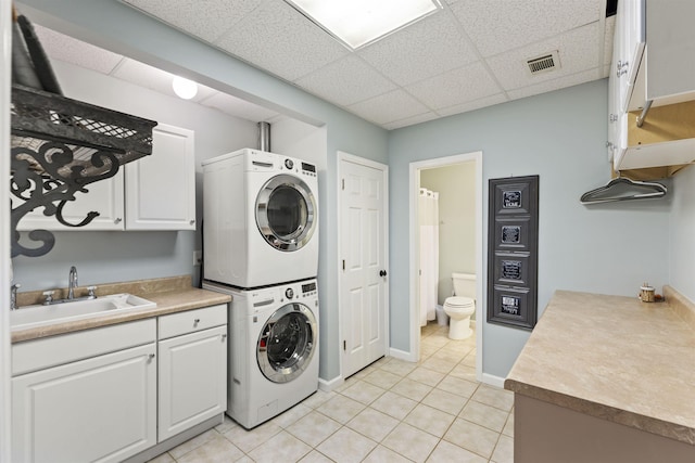 4410 Lower Apalachee Rd, Madison, GA 30650 - laundry area featuring a sink, stacked washer / dryer, light tile patterned flooring, visible vents, and baseboards