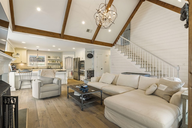 4410 Lower Apalachee Rd, Madison, GA 30650 - living area featuring a notable chandelier, light wood-style floors, stairs, and high vaulted ceiling