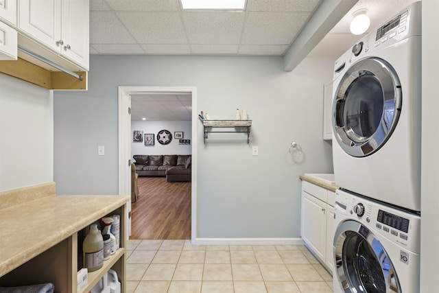4410 Lower Apalachee Rd, Madison, GA 30650 - laundry area featuring light tile patterned floors, baseboards, stacked washer and clothes dryer, and cabinet space