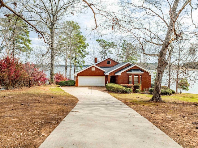 view of front of home featuring brick siding, an attached garage, concrete driveway, and a chimney