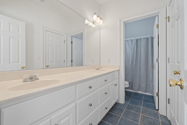 full bathroom featuring curtained shower, toilet, double vanity, tile patterned floors, and a sink