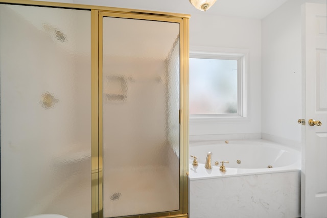 bathroom with a tub with jets and a stall shower