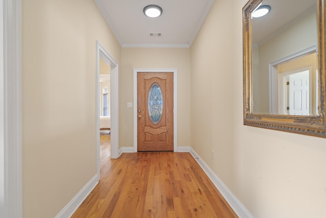 entryway with visible vents, light wood-style flooring, baseboards, and ornamental molding