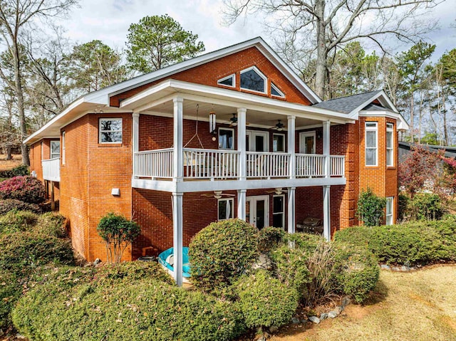 view of front of home with a ceiling fan and brick siding