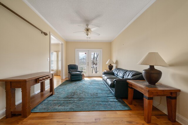 living area featuring ornamental molding, french doors, wood finished floors, a textured ceiling, and a ceiling fan