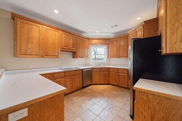 kitchen featuring visible vents, brown cabinets, a sink, appliances with stainless steel finishes, and light countertops