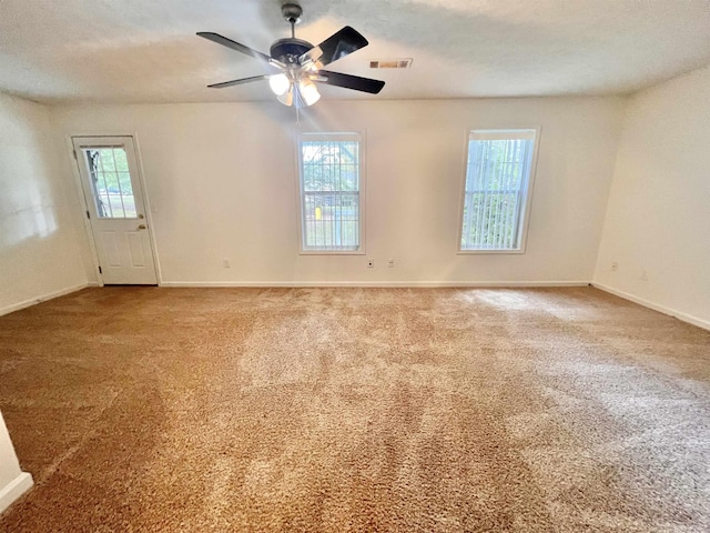 carpeted spare room featuring ceiling fan and a textured ceiling