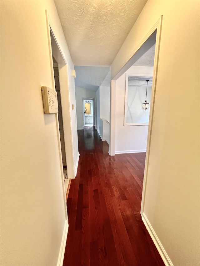 corridor featuring dark hardwood / wood-style floors and a textured ceiling