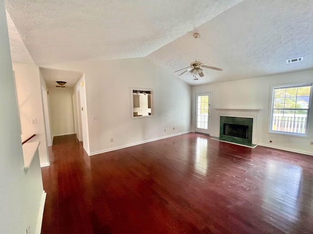 unfurnished living room with lofted ceiling, a high end fireplace, dark hardwood / wood-style floors, and a textured ceiling