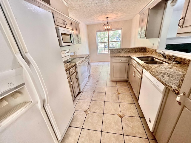 kitchen featuring decorative light fixtures, sink, light tile patterned floors, white appliances, and a textured ceiling