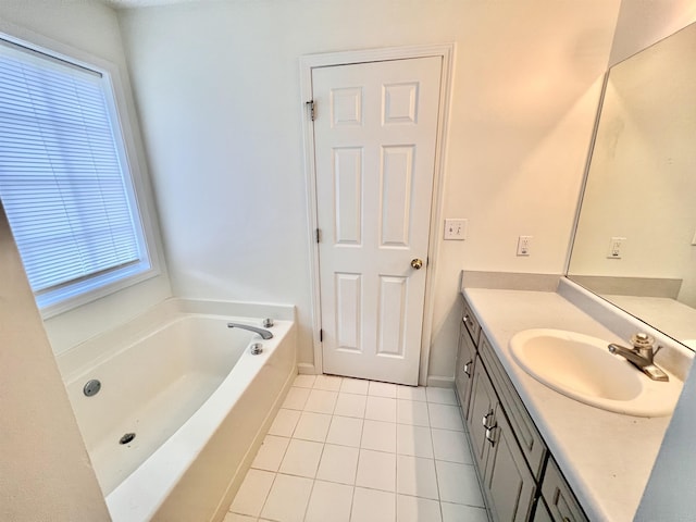 bathroom with vanity, a healthy amount of sunlight, a washtub, and tile patterned floors