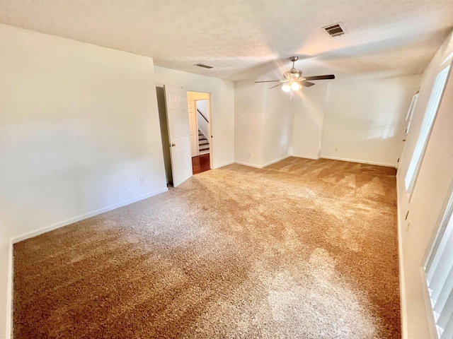 carpeted empty room with a textured ceiling and ceiling fan