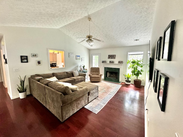 living room featuring dark hardwood / wood-style floors, vaulted ceiling, a premium fireplace, and a textured ceiling