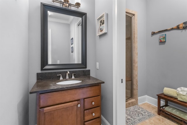 full bath with tile patterned floors, baseboards, crown molding, tiled shower, and vanity