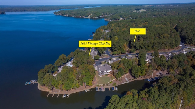 birds eye view of property with a wooded view and a water view